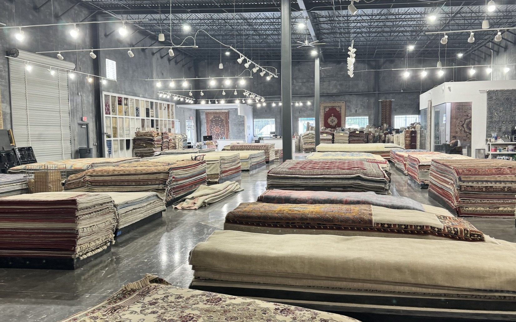 Inside the Arteverk Houston showroom — rows of one-of-a-kind hand-knotted rugs in the gallery